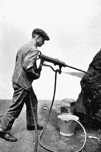 By permission of The Mining Engineering Co., Ltd., Sheffield
Pneumatic Hammer Drill
This tool is used by miners for making holes in hard rock, preliminary to
blasting. Note the spray of water, which prevents the stone dust rising and
getting into the miner's lungs.—See p. 220