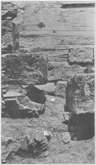 Figure 9

Looking north in the line of the eastern interior cross-wall. A view
showing the orthostate which was in contact with the interior wall and
the rough surface (X) of the native rock in the line of the latter