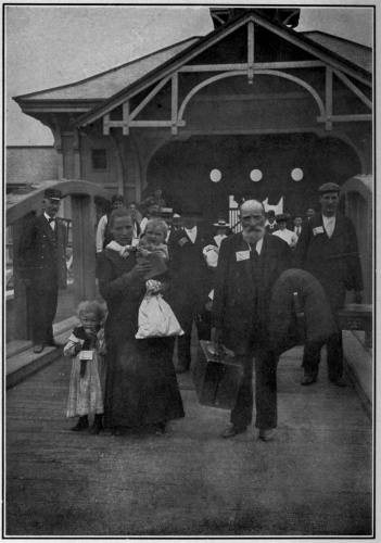 From stereograph copyright—1904, by Underwood & Underwood, N. Y.
AT THE GATE

With tickets fastened to coats and dresses, the immigrants pass out
through the gate to enter into their new inheritance, and become our
fellow citizens.
